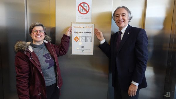 El delegado de Salud y Yolanda Morales poniendo un cartel de Escaleras es salud